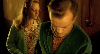 Movie still from “Delicatessen” (1991), directed by Marc Caro – A man and a woman are standing in a dimly - lit room; Medium shot, Low angle