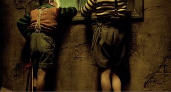 Movie still from “Delicatessen” (1991), directed by Marc Caro – Two children standing next to each other near a wall; Medium shot, Low angle