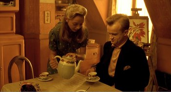 Movie still from “Delicatessen” (1991), directed by Marc Caro – A man and a woman sitting at a table with a tea pot; Medium shot, High angle