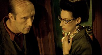 Movie still from “Delicatessen” (1991), directed by Marc Caro – A man and a woman looking at each other in a mirror; Close Up shot, Over the shoulder angle