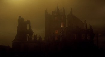 Movie still from “Delicatessen” (1991), directed by Marc Caro – A building that has been destroyed in the dark of the night; Extreme Wide shot, Low angle