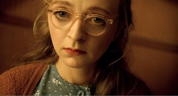 Movie still from “Delicatessen” (1991), directed by Marc Caro – A person wearing glasses; Close Up shot, High angle