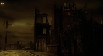 Movie still from “Delicatessen” (1991), directed by Marc Caro – An old building is in the middle of the night; Extreme Wide shot, Low angle