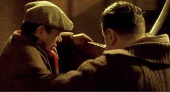 Movie still from “Delicatessen” (1991), directed by Marc Caro – Two men are shaving each other's hair; Medium shot, High angle
