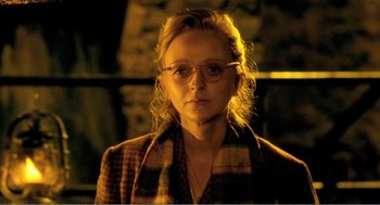Movie still from “Delicatessen” (1991), directed by Marc Caro – A woman wearing glasses and a plaid jacket; Close Up shot, Over the shoulder angle