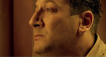 Movie still from “Delicatessen” (1991), directed by Marc Caro – A man's face in a dimly - lit room; Close Up shot, Low angle