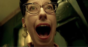 Movie still from “Delicatessen” (1991), directed by Marc Caro – A person wearing glasses with a mouth wide open; Close Up shot, Overhead angle