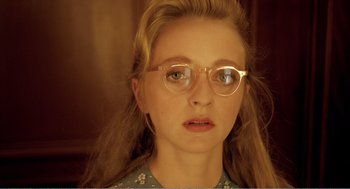 Movie still from “Delicatessen” (1991), directed by Marc Caro – A young woman wearing glasses looking at the camera; Close Up shot, Over the shoulder angle