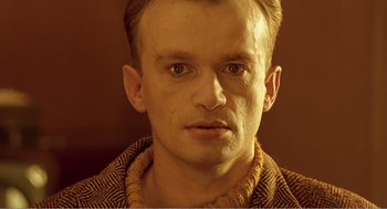 Movie still from “Delicatessen” (1991), directed by Marc Caro – A person wearing a sweater; Close Up shot, High angle