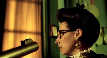 Movie still from “Delicatessen” (1991), directed by Marc Caro – A woman wearing glasses is looking into the distance; Close Up shot, Low angle