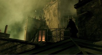 Movie still from “Delicatessen” (1991), directed by Marc Caro – A man standing on top of a building near a fire hydrant at night; Extreme Wide shot, Low angle
