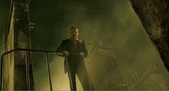 Movie still from “Delicatessen” (1991), directed by Marc Caro – A man standing on a railing in the dark; Wide shot, Low angle