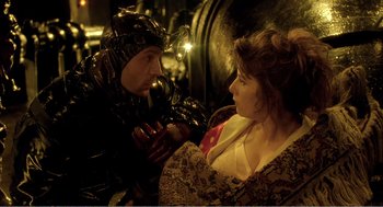 Movie still from “Delicatessen” (1991), directed by Marc Caro – A man and a woman dressed in costume; Medium shot, Over the shoulder angle