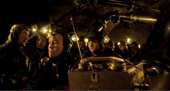 Movie still from “Delicatessen” (1991), directed by Marc Caro – A group of men in black suits and helmets; Medium shot, High angle