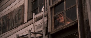Movie still from “Deliverance” (1972), directed by John Boorman – An older woman looking out of an old wooden window; Medium shot, Low angle