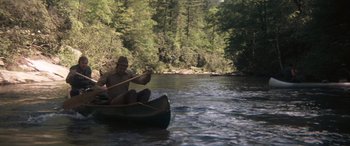 Movie still from “Deliverance” (1972), directed by John Boorman – A man is paddling a canoe down a river; Wide shot, High angle