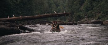 Movie still from “Deliverance” (1972), directed by John Boorman – A person in a canoe in the middle of a river; Wide shot, High angle