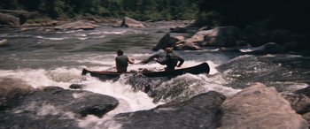 Movie still from “Deliverance” (1972), directed by John Boorman – Two men are paddling a canoe down a river; Wide shot, High angle