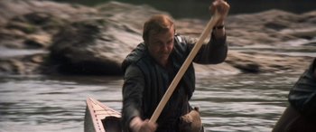 Movie still from “Deliverance” (1972), directed by John Boorman – A man rowing a boat on a body of water; Close Up shot, High angle
