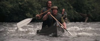 Movie still from “Deliverance” (1972), directed by John Boorman – Two men paddling a canoe down a river; Medium shot, High angle