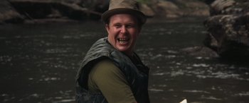 Movie still from “Deliverance” (1972), directed by John Boorman – A man in a hat and vest is in the water; Close Up shot, Low angle