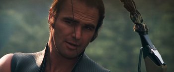 Movie still from “Deliverance” (1972), directed by John Boorman – A man's face with an arrow in his ear; Close Up shot, Over the shoulder angle