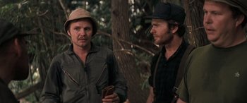 Movie still from “Deliverance” (1972), directed by John Boorman – Two men standing next to each other near a tree; Close Up shot, Over the shoulder angle