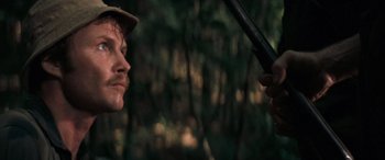 Movie still from “Deliverance” (1972), directed by John Boorman – A man holding a sword in a forest; Close Up shot, Over the shoulder angle