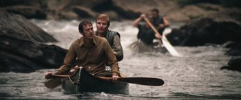 Movie still from “Deliverance” (1972), directed by John Boorman – A group of men paddling a canoe across a river; Wide shot, High angle