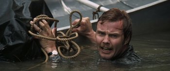 Movie still from “Deliverance” (1972), directed by John Boorman – A man in the water holding onto a rope; Close Up shot, High angle