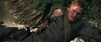 Movie still from “Deliverance” (1972), directed by John Boorman – A man with a rope around his neck and arm; Medium shot, High angle