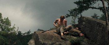 Movie still from “Deliverance” (1972), directed by John Boorman – A man sitting on top of a rock on top of a mountain; Wide shot, Low angle