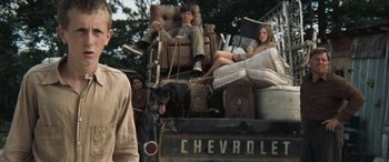 Movie still from “Deliverance” (1972), directed by John Boorman – A man and a woman sitting on the back of a truck with a dog; Medium shot, Low angle