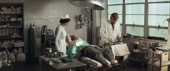 Movie still from “Deliverance” (1972), directed by John Boorman – A man laying on the ground in a hospital bed; Wide shot, High angle