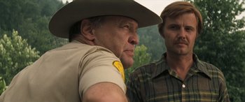 Movie still from “Deliverance” (1972), directed by John Boorman – A man in a cowboy hat and a man in a plaid shirt; Close Up shot, Over the shoulder angle