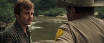 Movie still from “Deliverance” (1972), directed by John Boorman – A man and a woman are standing next to each other; Close Up shot, Over the shoulder angle