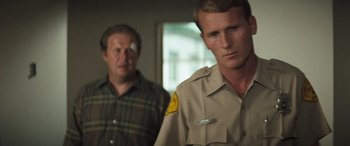 Movie still from “Deliverance” (1972), directed by John Boorman – Two men standing next to each other in front of a window; Close Up shot, Over the shoulder angle