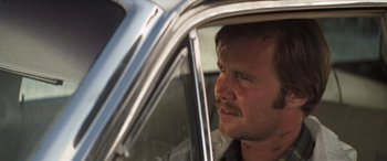 Movie still from “Deliverance” (1972), directed by John Boorman – A person sitting in a car looking out of the window; Close Up shot, Over the shoulder angle