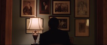 Movie still from “Demolition” (2015), directed by Jean-Marc Vallée – A man sitting in front of a wall of pictures; Medium shot, Over the shoulder angle