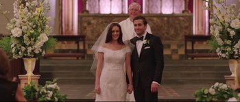 Movie still from “Demolition” (2015), directed by Jean-Marc Vallée – A bride and groom posing for a picture in front of a priest; Medium shot, Over the shoulder angle