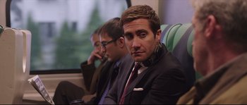 Movie still from “Demolition” (2015), directed by Jean-Marc Vallée – A man sitting next to another man on a train; Close Up shot, Over the shoulder angle