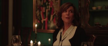 Movie still from “Demolition” (2015), directed by Jean-Marc Vallée – A woman standing in front of a painting and candles; Medium shot, Over the shoulder angle
