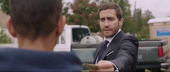 Movie still from “Demolition” (2015), directed by Jean-Marc Vallée – A man wearing a suit and tie holding a piece of paper in his hand; Close Up shot, Over the shoulder angle