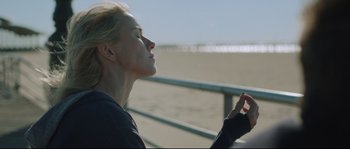 Movie still from “Demolition” (2015), directed by Jean-Marc Vallée – A woman sitting on a bench with her eyes closed; Close Up shot, Over the shoulder angle