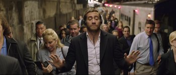 Movie still from “Demolition” (2015), directed by Jean-Marc Vallée – A man in a black jacket and headphones in a crowd of onlookers; Medium shot, Over the shoulder angle
