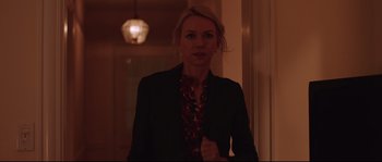 Movie still from “Demolition” (2015), directed by Jean-Marc Vallée – A woman in a black jacket is standing in a dark room; Medium shot, Over the shoulder angle