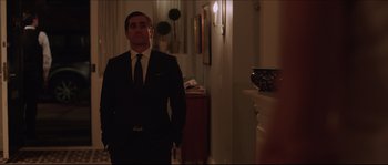Movie still from “Demolition” (2015), directed by Jean-Marc Vallée – A man wearing a suit and tie standing in a room; Medium shot, Over the shoulder angle