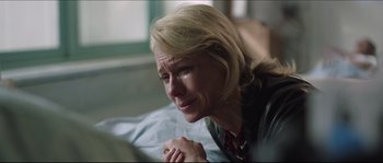 Movie still from “Demolition” (2015), directed by Jean-Marc Vallée – A woman sitting on a bed crying with her eyes closed; Close Up shot, Over the shoulder angle