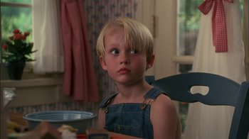 Movie still from “Dennis the Menace” (1993), directed by Nick Castle – A little boy sitting at a dining room table; Close Up shot, Over the shoulder angle