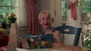 Movie still from “Dennis the Menace” (1993), directed by Nick Castle – A little boy sitting at a table in a room; Close Up shot, Over the shoulder angle
